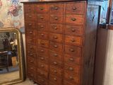 a dresser and mirror in a room with a mirror on the wall