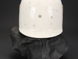 a white helmet sitting on top of a piece of leather