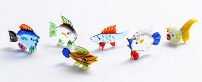 de nombreux poissons en verre de différentes couleurs sur un fond blanc