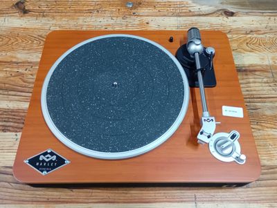 a turntable on a wooden table with a metal object