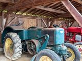deux vieux tracteurs dans une grange au toit en bois