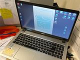 un ordinateur portable posé sur un bureau, à côté d'une pile de papiers