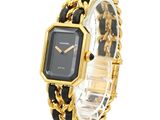an image of a black and gold watch with a chain around it