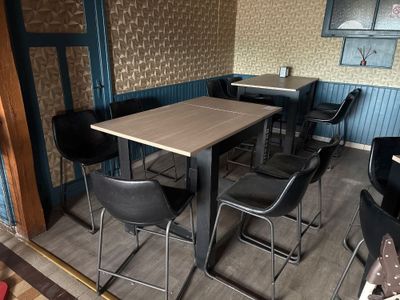 tables and chairs in a room with a wallpapered wall behind them