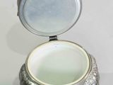 a silver container with a lid that has a silver animal on it