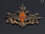 an orange and silver badge with a crown on top of a black background