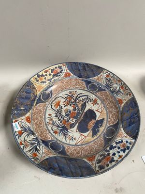 une assiette bleue et orange posée sur une table à côté d'une tasse et d'une soucoupe