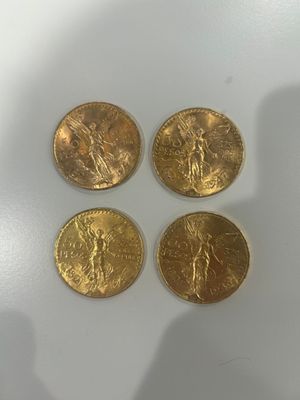 quatre pièces d'or posées sur une surface blanche