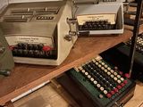 several old typewriters are sitting on a shelf in a room