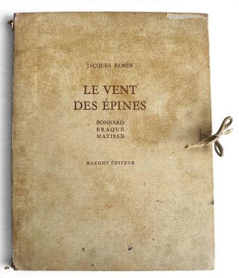 un vieux livre posé sur une table blanche, à côté d'une ficelle