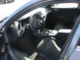 the interior of a car with the door open and the driver ' s seat down