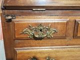 a wooden chest of drawers with brass handles on it