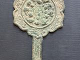 un vieux miroir en bronze orné d'un motif floral