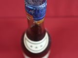a small bottle with a blue lid on a red surface