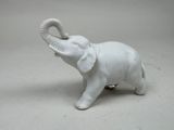 a white elephant figurine that is standing on a table