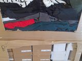 many boxes of clothing on a pallet in a warehouse