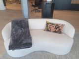 a white couch with two pillows on it in a living room