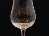 a glass of wine sitting on a table with a black background