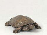 small bronze turtle figurine on a white background