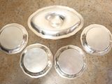 four silver plates with lids on a marble table