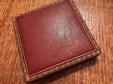 a red leather wallet sitting on top of a wooden table