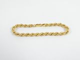 a gold rope bracelet with a clasp on a white background