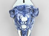 a blue and white vase with a cow head on it