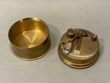 a small brass object on a table next to a smaller one