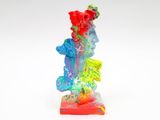 figurine aux couleurs vives représentant une femme tenant une fleur, posée sur un fond blanc