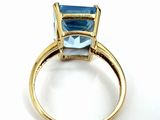 an image of a gold ring with a blue topaz stone