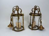 pair of brass and glass lanterns with tassels hanging from them