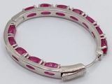 an image of a bracelet with pink stones on a white surface