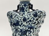 vase bleu et blanc orné d'un papillon sur le col