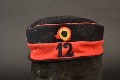 un chapeau noir orné d'un ruban rouge et un chapeau noir sur lequel figure le chiffre 12