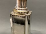 a small silver bottle with a gold top on a table