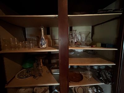 de nombreux plats et verres sur les étagères de la cuisine