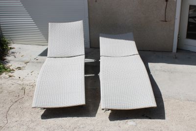 deux chaises longues posées sur le béton devant un immeuble