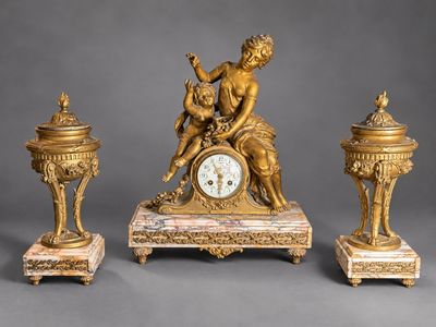 une horloge en or surmontée d'une statue