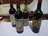 trois bouteilles de vin posées sur une table à côté d'une lampe