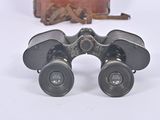 a pair of binoculars sitting on a table next to a suitcase