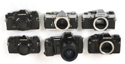 six cameras are lined up in a row on a white surface