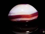 a red and white marble on a black surface