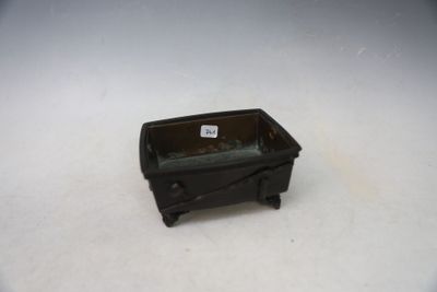 a small black planter sitting on top of a white table