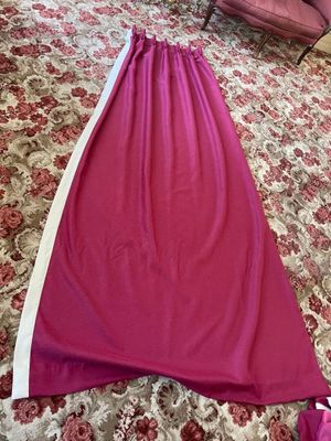 pink and white dress on a bed with a pink chair and a pink chair