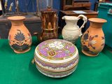 trois vases et une boîte posés sur une table verte