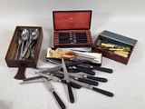 many different types of knives and spoons in a box