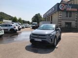 des voitures garées sur un parking devant un immeuble où est accrochée une pancarte indiquant « uniquement »