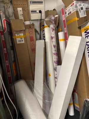 a pile of boxes and rolls of wrapping in a storage room