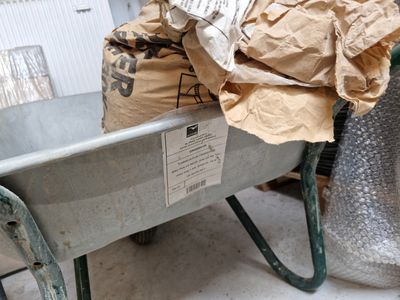 une brouette en métal contenant un sac en papier