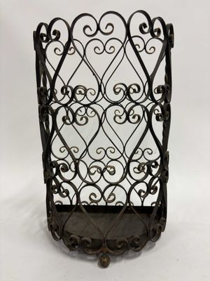 un porte-revues en fer noir orné de motifs en volutes